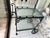 Vintage wrought iron bar /tea cart. It has 2 Tier Glass tops measuring 18” x26”. Black iron, with acorn and leaf motif....