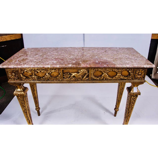 A beautifully scaled Louis XVI-style giltwood sofa table or console, richly decorated with carved neoclassical...