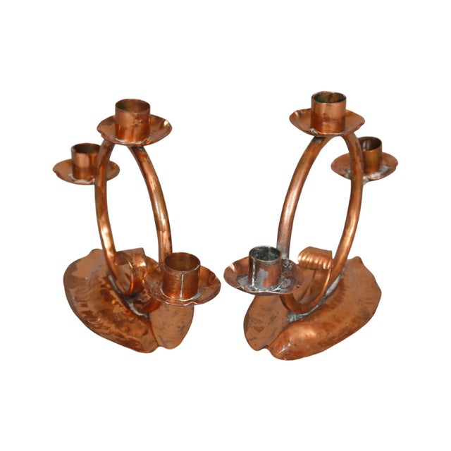 A pair of hand hammered copper swirl candelabra by Craftsman Studios of Laguna Beach, California. A round curled piece of...