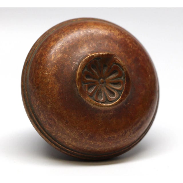 Radial design knob with a concave floral center. The knob has a small dent in the middle. The manufacturer and date of...