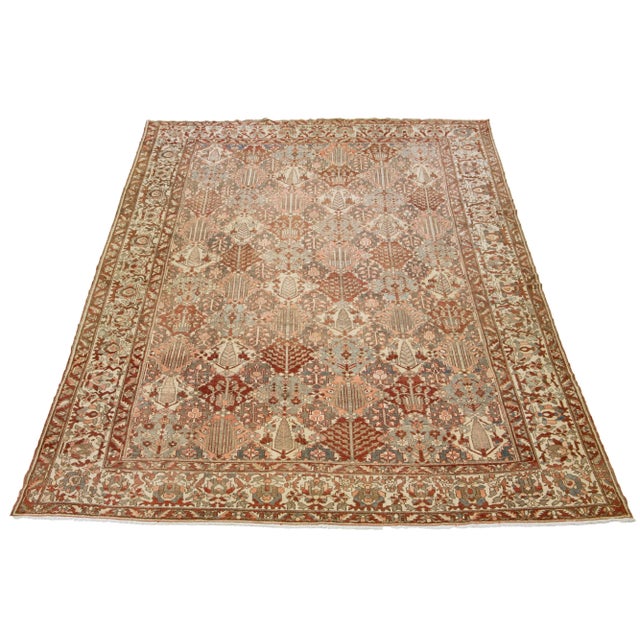 Beautiful Antique Bakhtiari hand-knotted wool rug with a gray, red-rust, beige, and pink color field. This Persian piece...