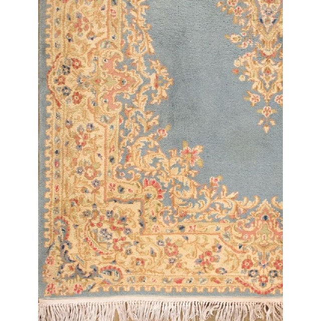 Hand-woven wool and cotton soft blue Persian Kirman rug with central medallion.
