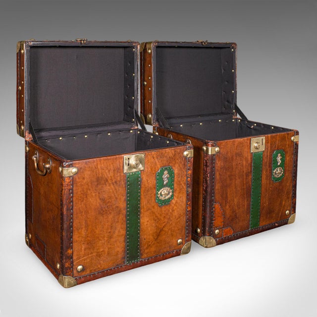 This is a late vintage pair of luggage cases. An English, leather and brass bedside nightstand, or occasional tables with...