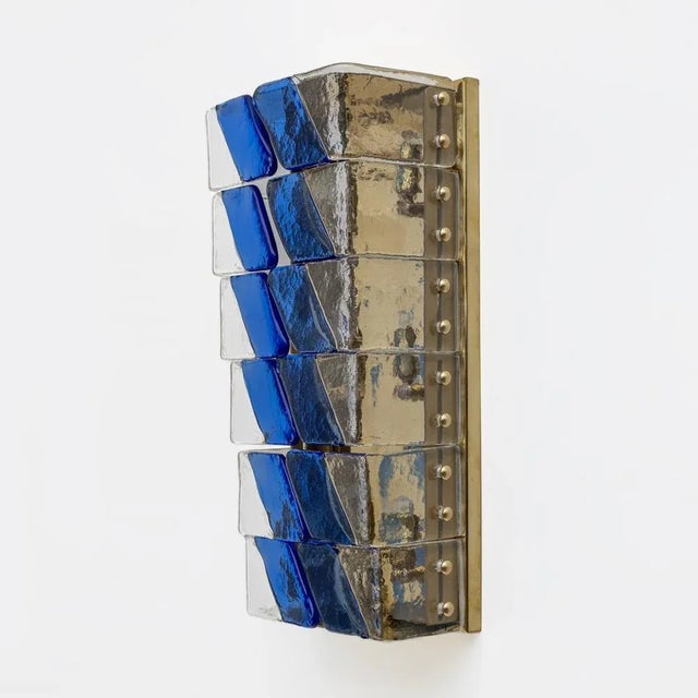 This pair of lamps is made of a series of Murano glasses overlapping in a graduated pattern. The glasses have two shades...