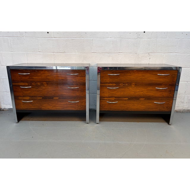 A sleek and sophisticated pair of mid-century modern three-drawer dressers, showcasing the striking contrast of richly...