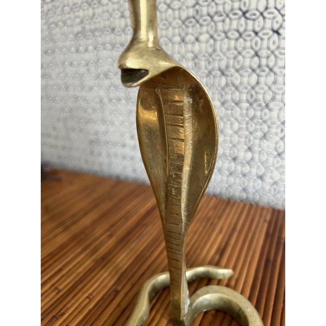 A vintage brass cobra-form candleholder with hand done detailing. Candleholder is mad up of two pieces- top portion screw...
