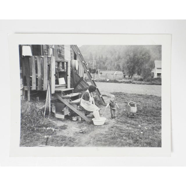 Early 20th century snapshot photograph of a hardworking mom soaking her feet. Seated at the bottom the stairs of a rough...