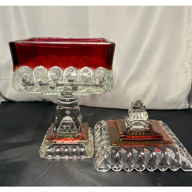 Westmorland ruby red or "ruby flash" candy dish or compote. The vintage glassware piece features a clear glass base and...