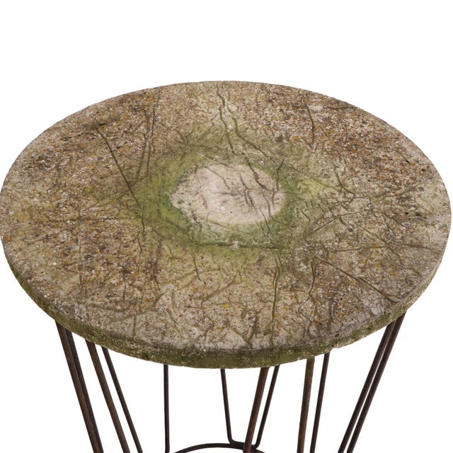 This round accent table features a rustic and patinaed stone top with an open-wire, tapered metal rod base. The airy...