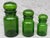Vintage set of three green glass lidded apothecary jars. Small, medium and large. Bubble shaped lids with large plastic...