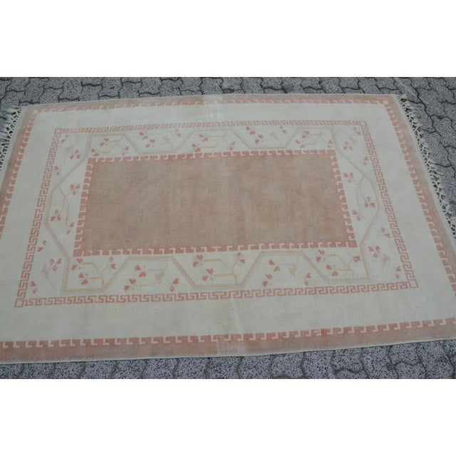 This is a vintage Turkish Oushak rug from the 1960s. The piece was hand-knotted.