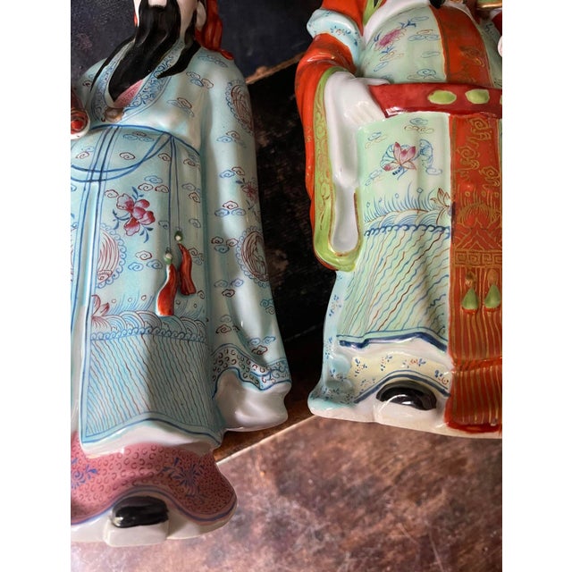 Lovely pair of porcelain statues, each depicting, a a Chinese immortal. Presented in traditional robes with lovely floral...