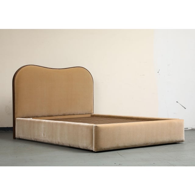 Inspired by a vintage silhouette that feels contemporary, this Queen bed frame is upholstered in a camel brown faux...