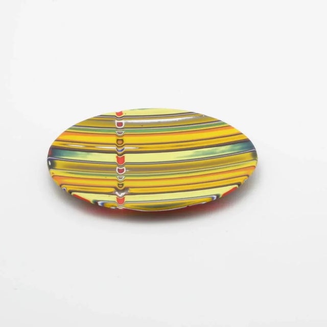 Murano glass plate made by melting together sections of glass rods in a furnace, with each section depicting a small...