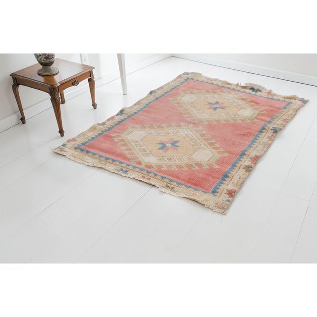 This is a vintage Turkish Oushak rug from the Mid 20th Century. The piece was hand-knotted.