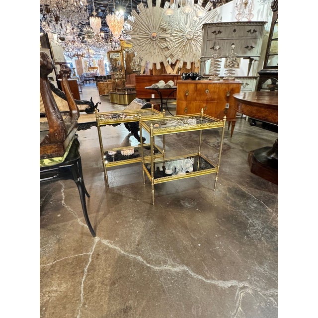 The Pair of Jansen Manner Brass and Black Glass Tables is a stylish and elegant addition to any living room. Ideal for...