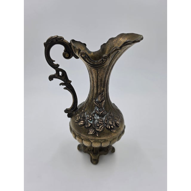 This vintage ornate Italian brass ewer features classic Rococo-inspired craftsmanship. Designed with a high-sweeping...