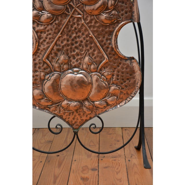 K0653 stylish late victorian arts and crafts fire screen, having hand rolled and beaten shield shaped copper panel of...