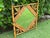 A charming vintage bamboo and rattan wall mirror featuring a diamond-form mirror plate framed by carved leaf details. The...