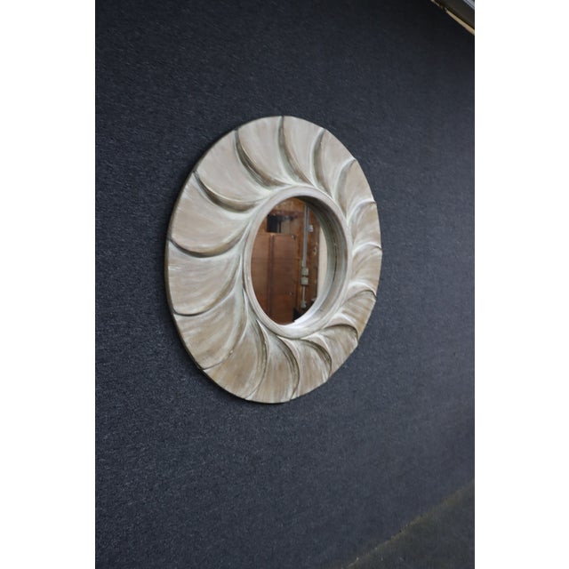 Mid-Century Modern style carved sunburst wall mirror featuring a dynamic spiral design with deeply carved radiating...