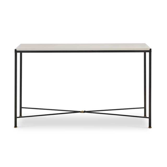 The contemporary neoclassical console with a honed limestone top and brass knot detail embodies the enduring influence of...