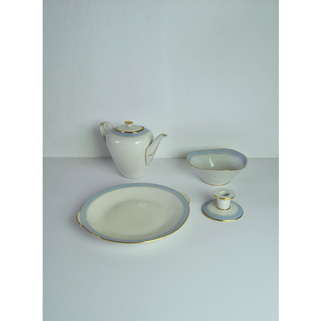 Elegant porcelain set containing a coffee pot, bowl, dish and candle holder. It is decorated in light blue on off-white...