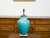 A turquoise Asian table lamp from the mid 20th century, with lucite base. Created during the midcentury period, this table...