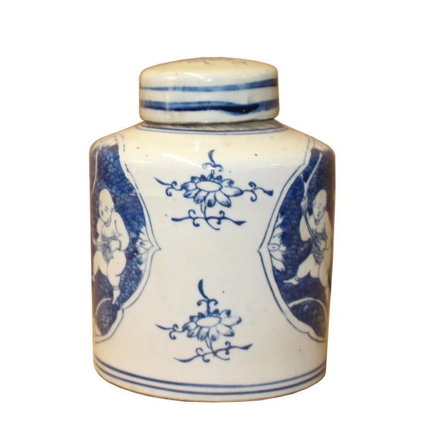 This is a handmade ceramic container urn jar in the white base color. The surface has a blue color oriental double kids...