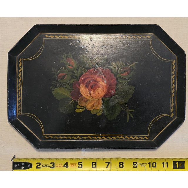 Antique 19th-century toleware tray with a black lacquered ground, hand-painted floral bouquet centered with a rose and...
