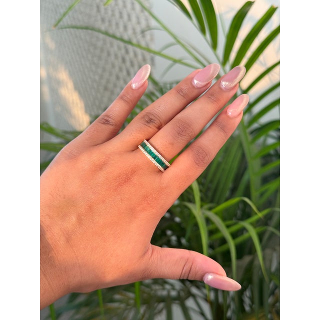 This eternity band features a 1 carat baguette cut emerald and diamond set in 14K yellow gold. Each emerald measuring...