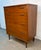 This Mid-Century Modern 4-drawer highboy dresser features a clean, minimalist silhouette and a beautiful wood grain...