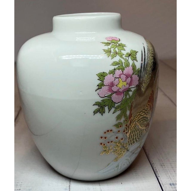 Beautiful decorated small vase or urn featuring floral decorations and pheasants or birds on a white background. Width and...