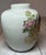 Beautiful decorated small vase or urn featuring floral decorations and pheasants or birds on a white background. Width and...
