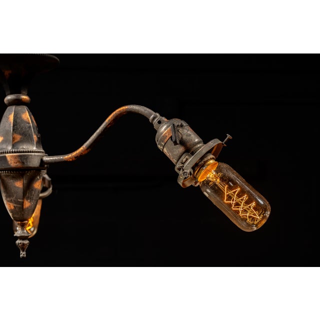 Antique triple-arm gooseneck chandelier constructed from copper with a dark japanned finish. Three curved arms extend from...