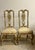 The upholstered seats are finished in a light, subtly textured fabric that beautifully complements the gilt frames,...
