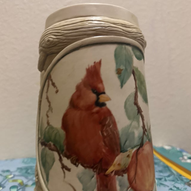 Ducks Unlimited collector's stein featuring a striking northern cardinal perched among apple branches. This stoneware...