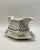 A cloverleaf pattern sauce boat with fluted spout, squared handle and attached diamond drip plate.