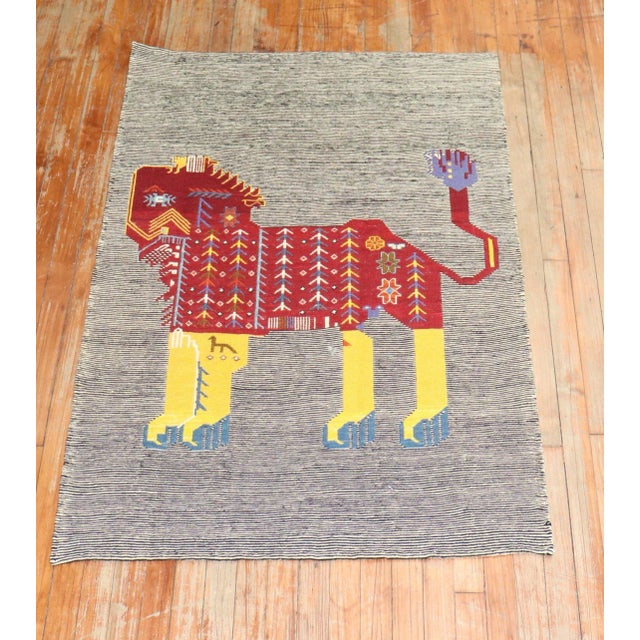 Scatter size Persian Kilim from the late 20th century with a lion on a striped field. can be used as a wall hanging too