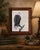 A beautifully framed signed wildlife print depicting a majestic American Bald Eagle perched on a weathered tree branch by...