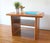 This is a mid century Scandinavian style teak table by Nordic Furniture that has tapered surfboard edges and bottom shelf....