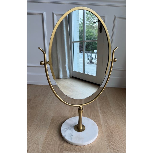An exceptional and substantial oversized solid brass and Carrara marble vanity mirror attributed to Charles Hollis Jones,...