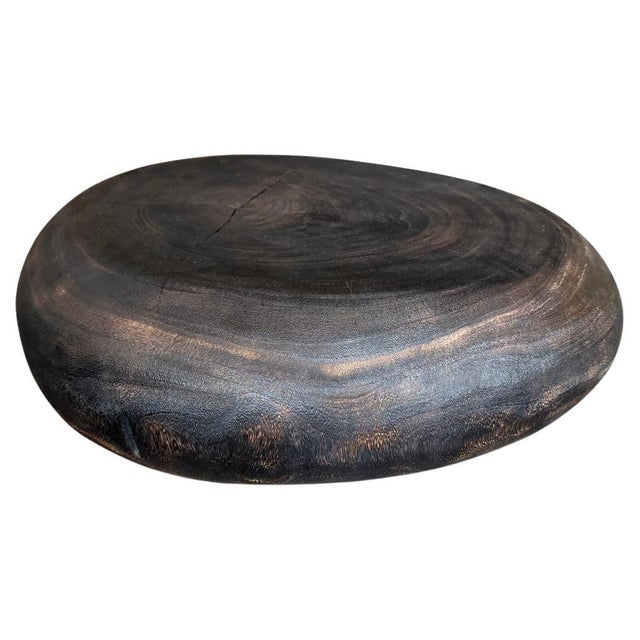 A minimalist pebble style low profile coffee table. Hand carved from a single piece of suar wood. Charred a rich brown...