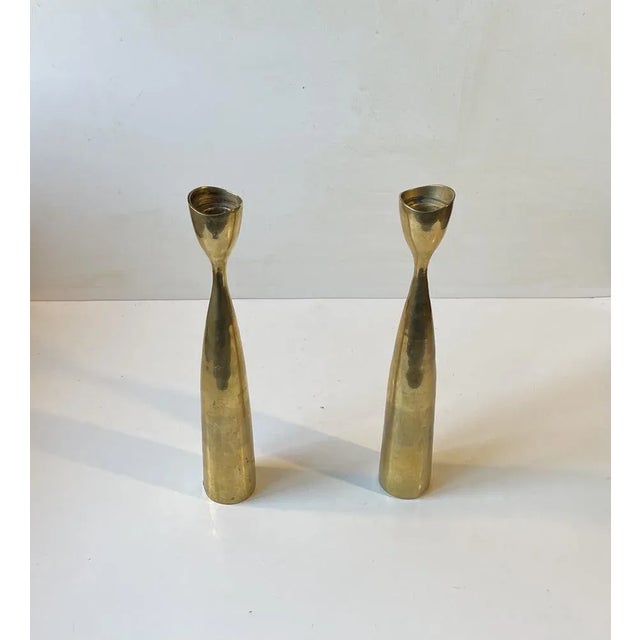 A pair of tall organically shaped tulip candlesticks in brass. Designed and manufactured in Scandinavia during the 1960s...