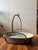 A heavy-duty industrial basin with a sturdy arched handle and hook. This is a raw, primitive farmhouse object with a...