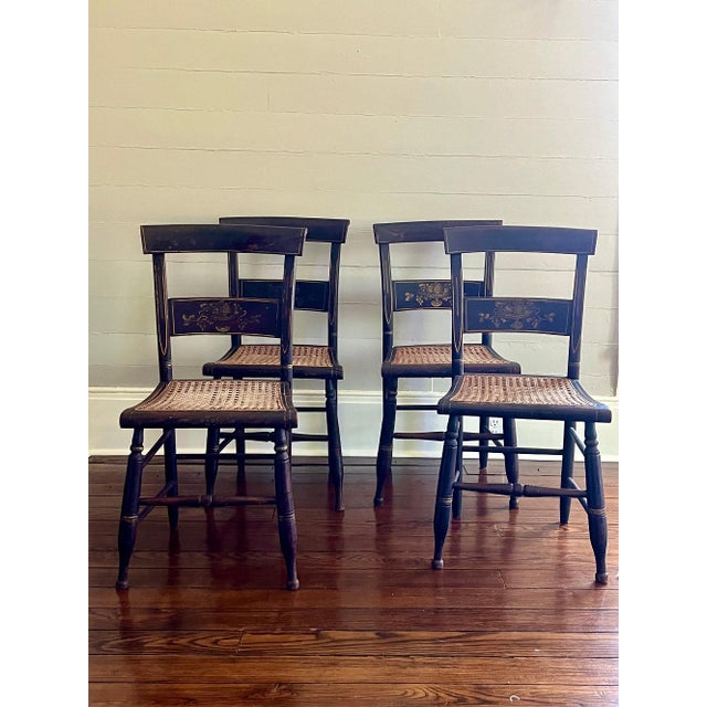 A lovely set of four black painted, carved side chairs with open splats, turned front legs, and splayed back legs. Painted...