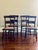 A lovely set of four black painted, carved side chairs with open splats, turned front legs, and splayed back legs. Painted...