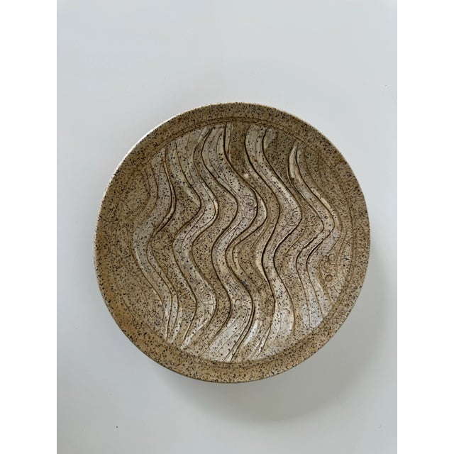This plate by American artist Charles Counts Rising Fawn presents a beautifully handcrafted ceramic plate with an earthy,...