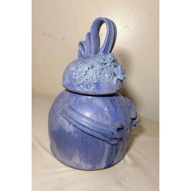 This handmade Patty DeBenedict purple studio pottery lidded jar is a whimsical piece featuring a stylized monster form....