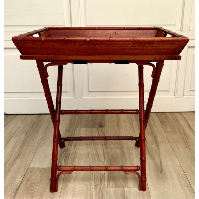 Here is a vintage faux bamboo butler’s tray table dating to the late 20th century. Finished in a warm reddish-brown tone,...