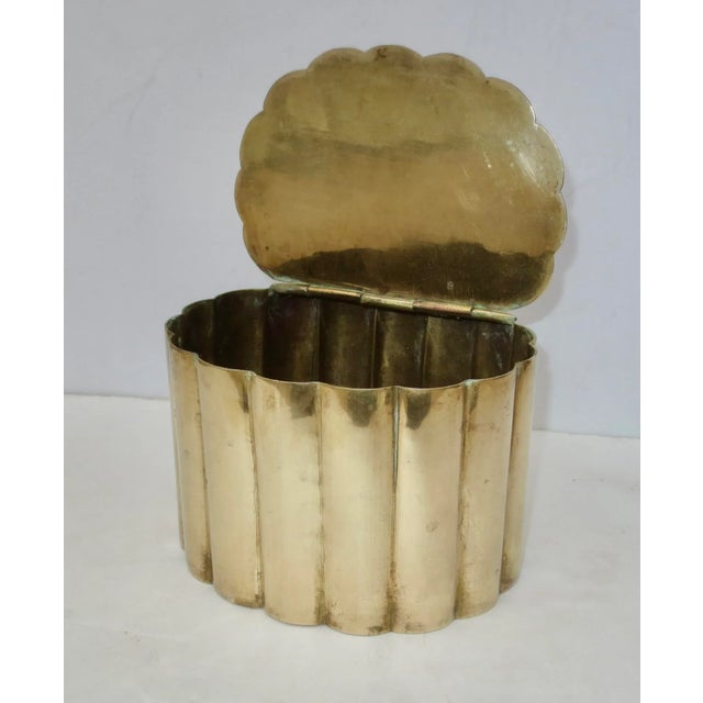 Brass desk container box. Solid sheet brass rolled into a cylindrical box with 16 rolled lobes. The lid is hinged across...